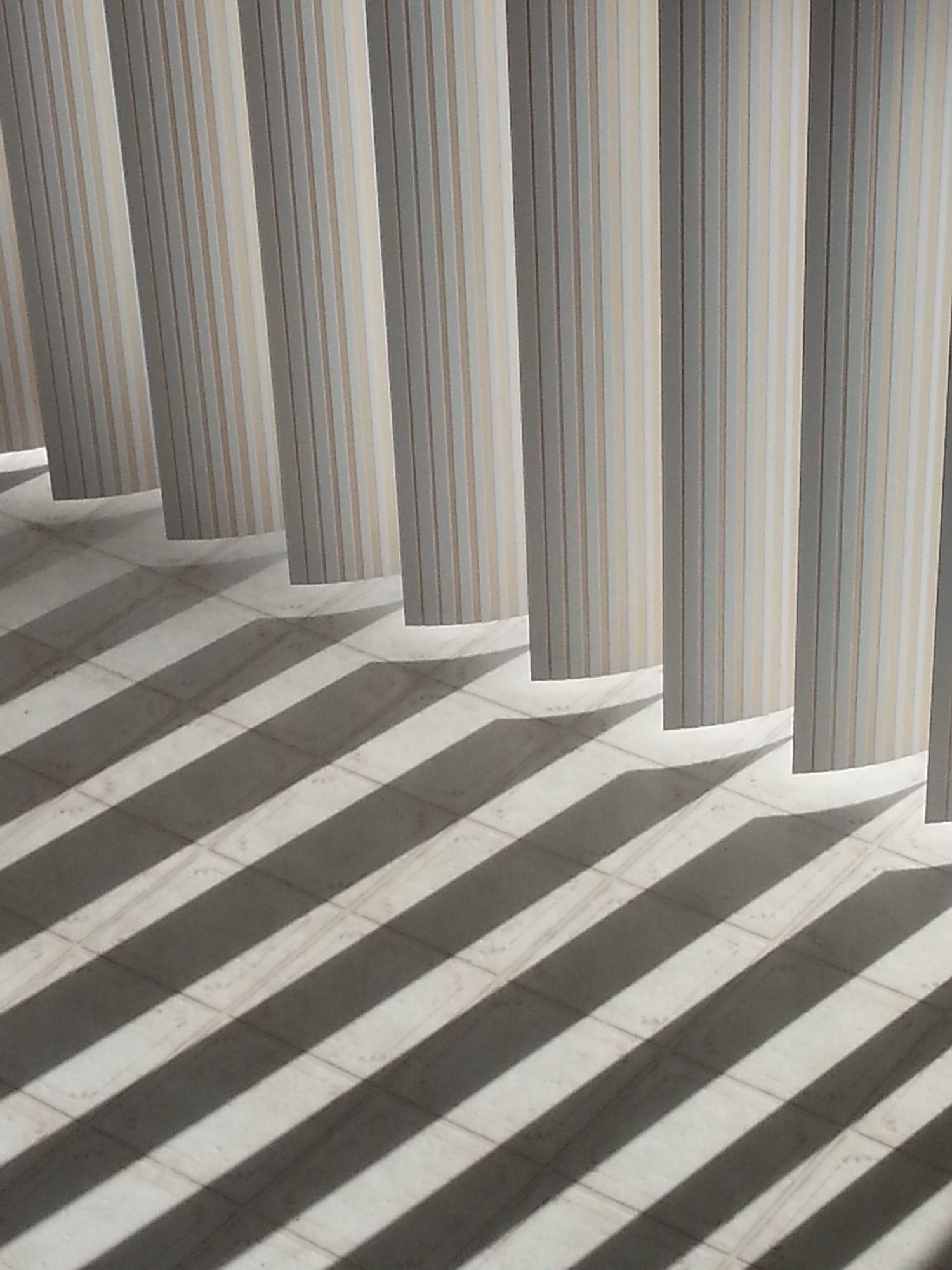 Abstract vertical blind shadows on linoleum floor